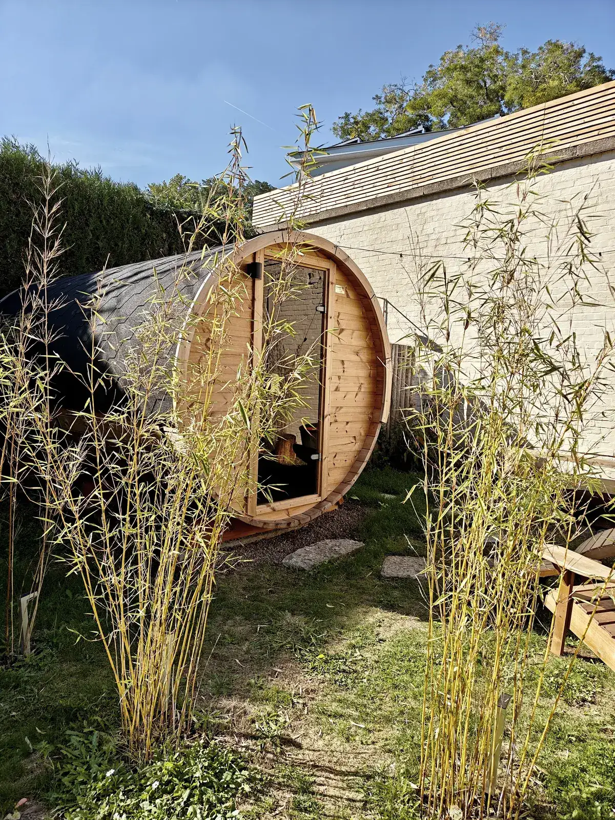 De sauna van STIMULHUS met de muur en bamboe in daglicht